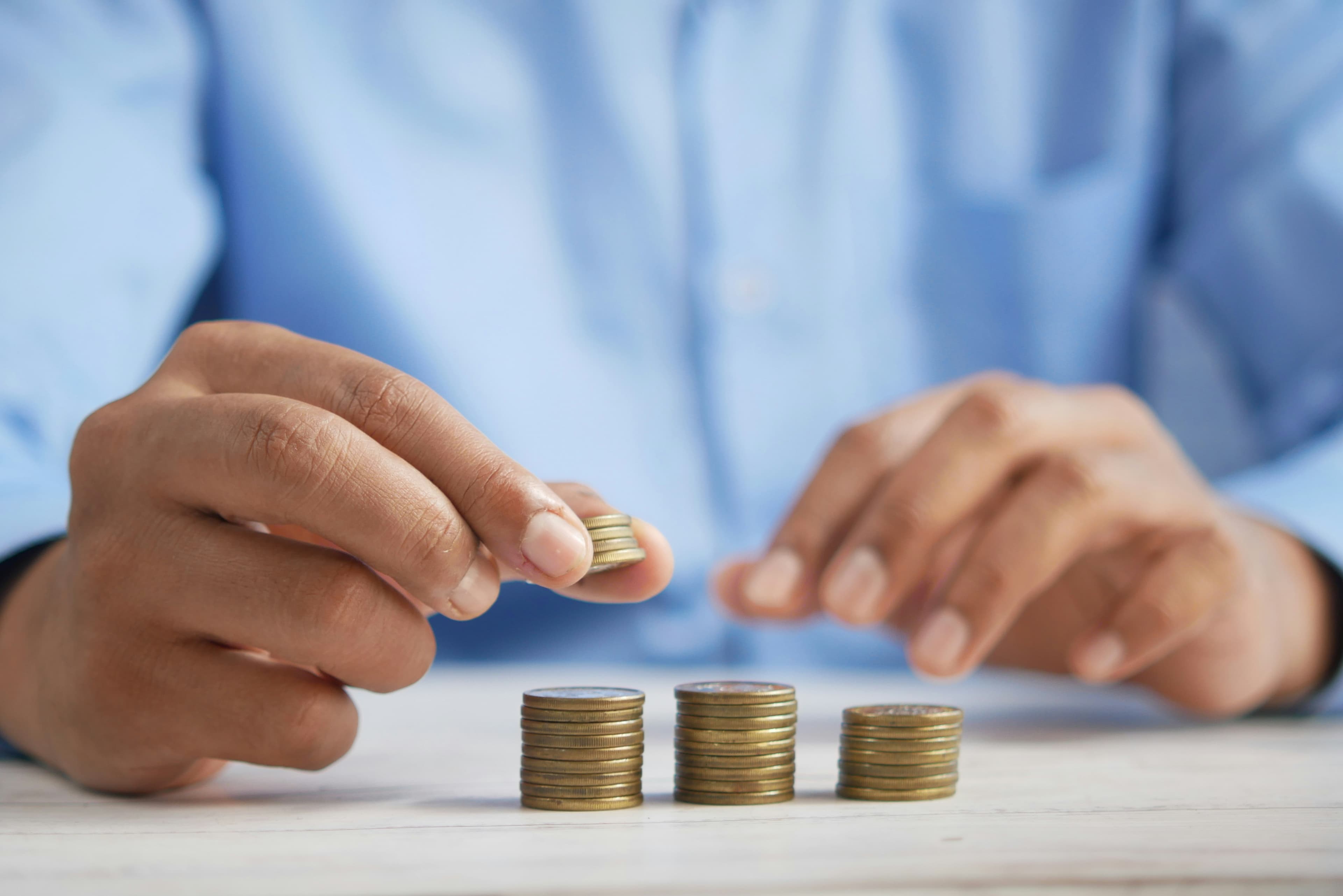 Man arranging stacked coins on a table